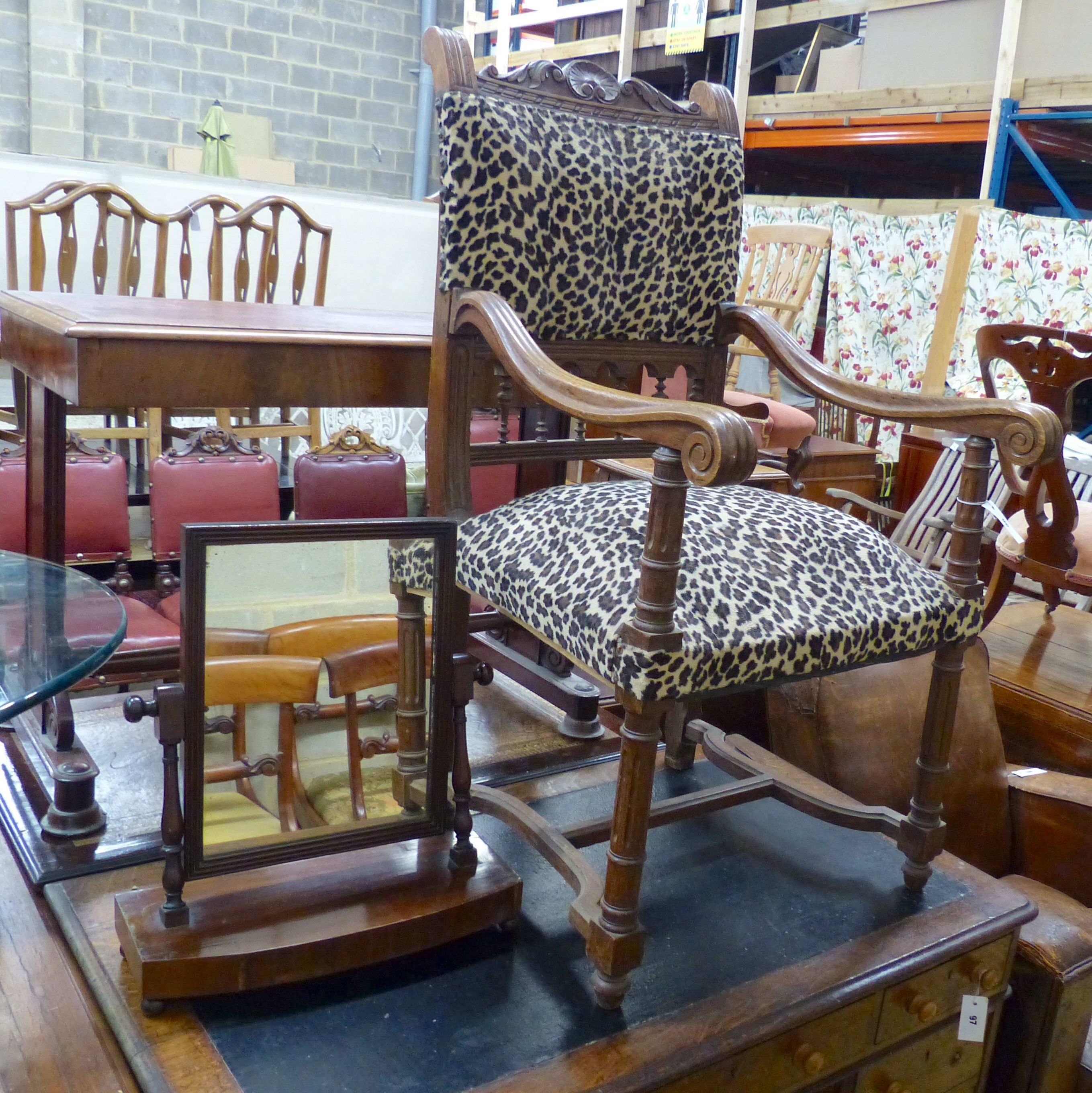 A late 19th century leopard print upholstered wooden elbow chair and a mahogany toilet mirror